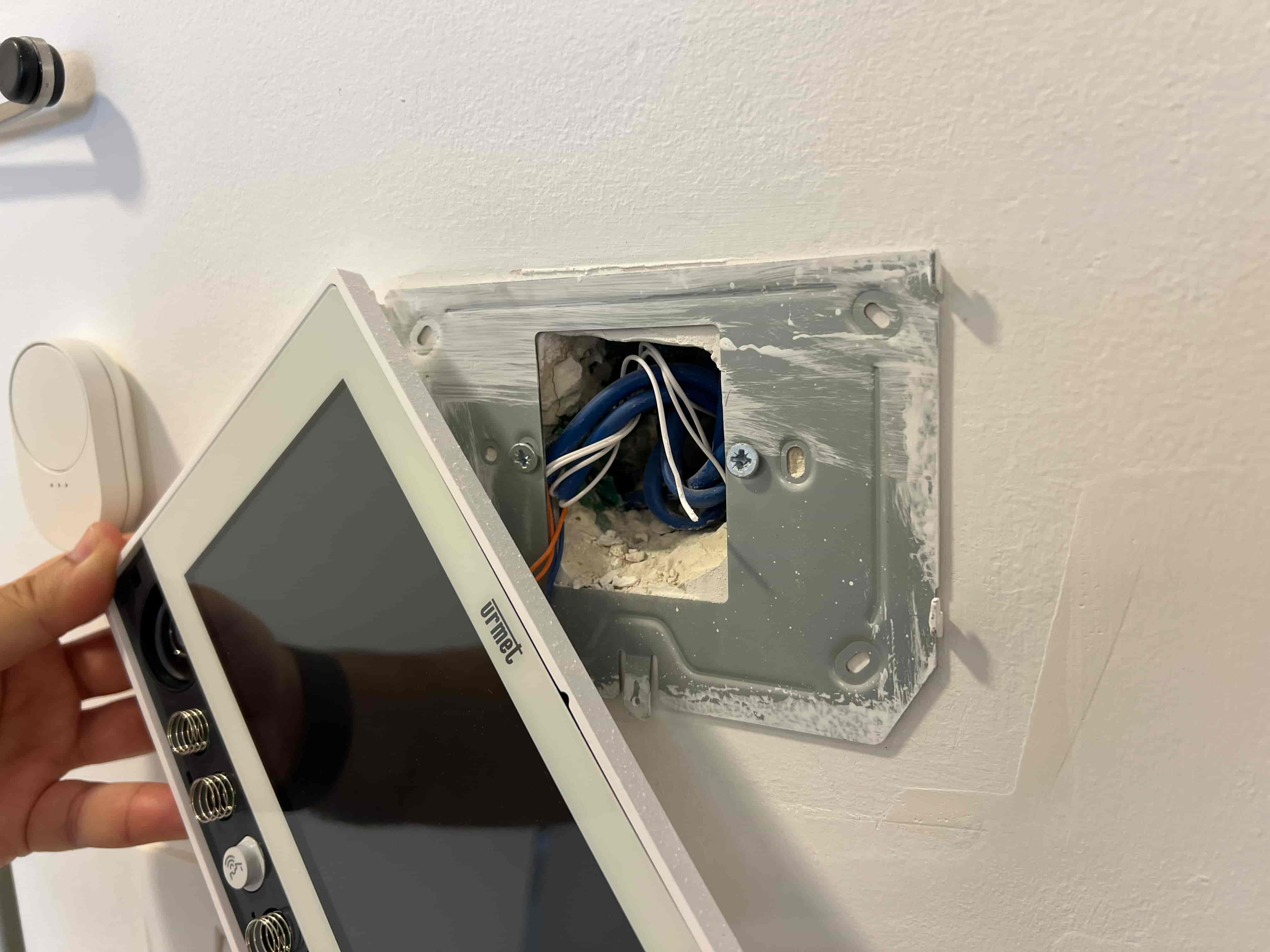 Home intercom opened to wire the lobby door release through an in-wall module