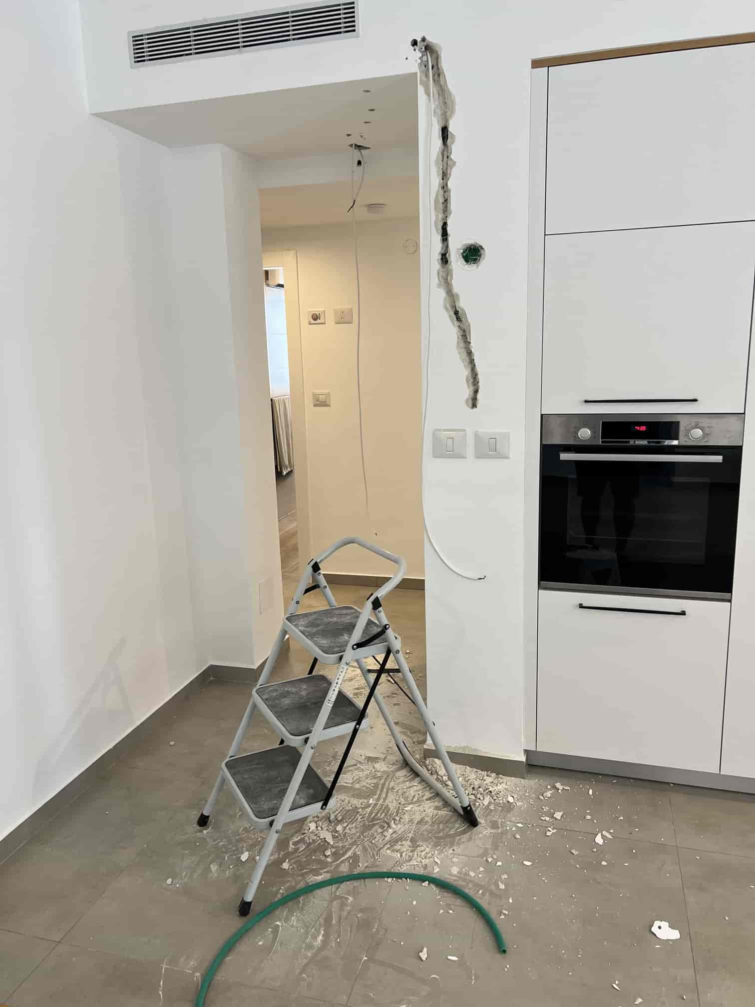 Wall opened near a ladder to create a wiring path for the smart home retrofit