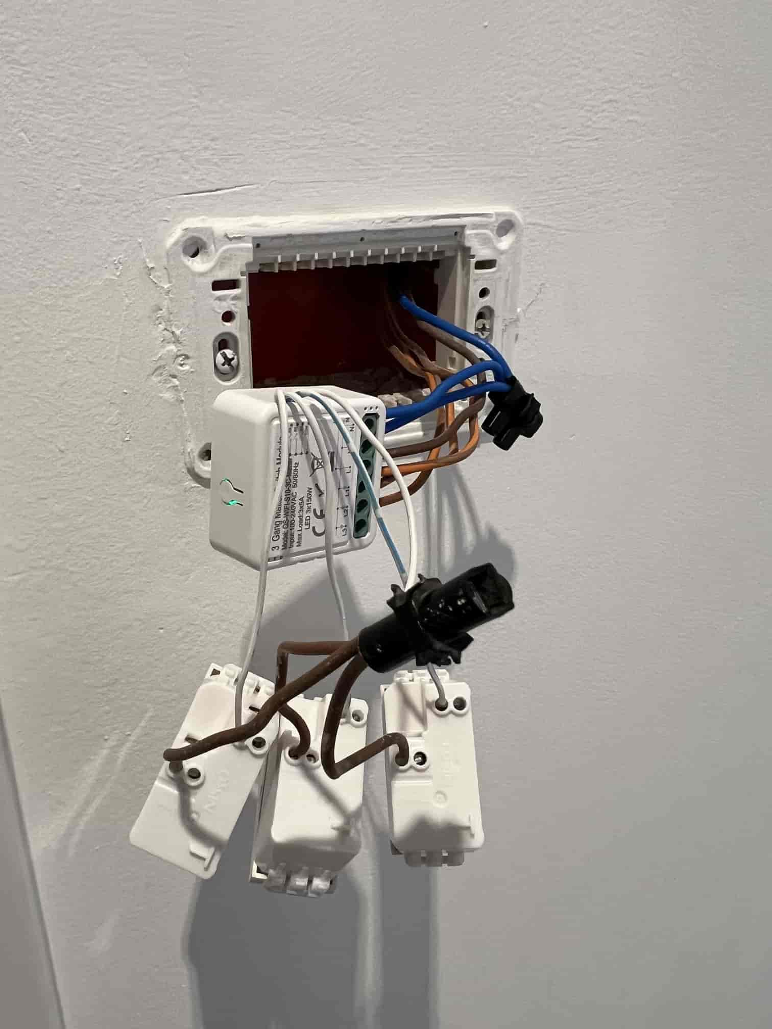 In-wall smart module wiring connected behind a switch box